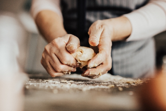 Womans hands kneading dough 