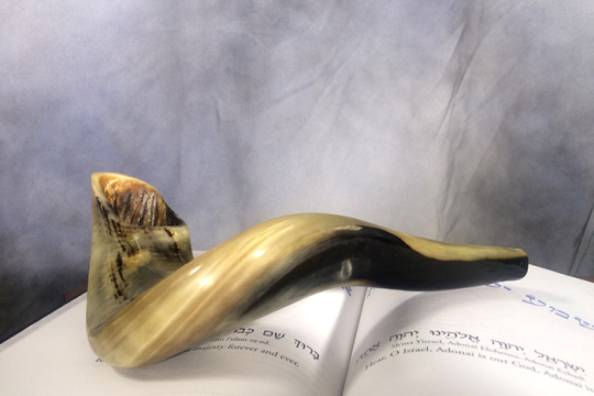 shofar laying on a prayer book