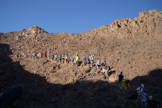 Photo of a group of people hiking down a mountain